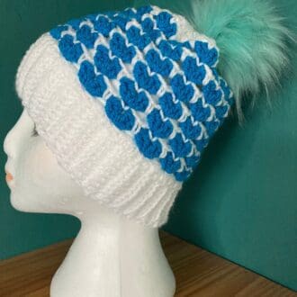 A Handcrafted Blue and White Beanie Hat with detachable Faux Pom Pom