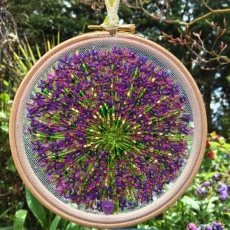 An embroidered beaded Allium sewn on mesh on a 6" hoop