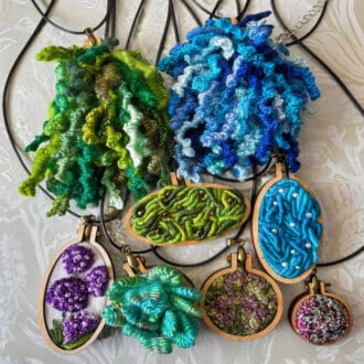 A mix of contemporary, modern embroidered pendants in various designs.