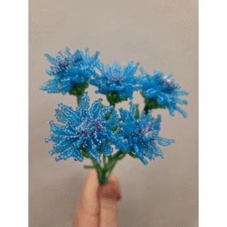 Pictured is Five french beaded blue cornflowers held against a white background