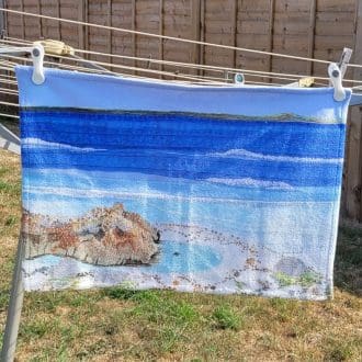 Rock pool tea towel printed from original embroidery.