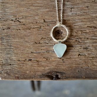 seafoam blue sea glass strung from a molten silver ring on a silver chain