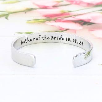 a hammered texture 9mm aluminium cuff bracelet with the words Mother of the Bride or Groom hand-stamped inside along with the date of the wedding