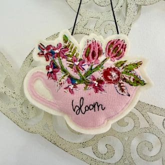 Pretty textile pink teacup filled with flowers, tea lovers decoration